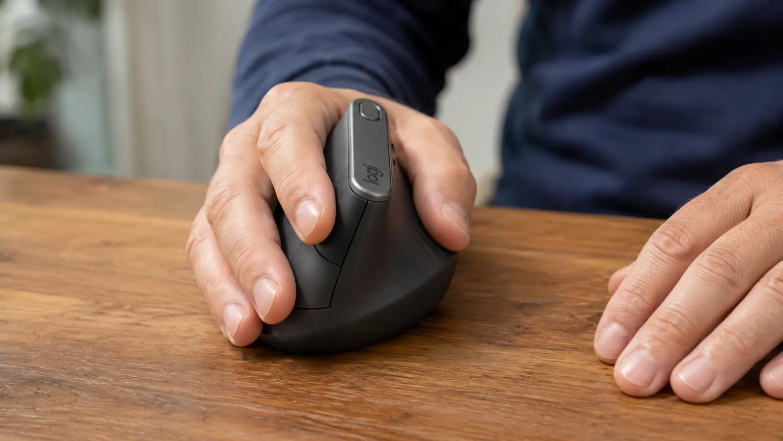 Hand gripping the Logitech MX Vertical mouse showing the natural handshake angle from the side