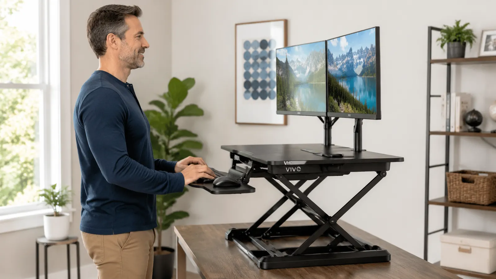 Close-up of the VIVO desk converter gas spring mechanism raising the work surface with a keyboard and monitor on top